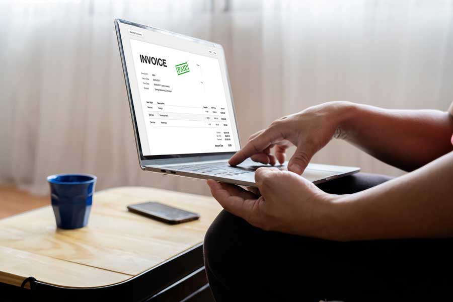 online invoice payment on a laptop, happy client